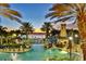 Resort-style pool with a charming lighthouse structure and water slide, surrounded by palm trees and a tranquil lake at 217 Oceania Ct, Apollo Beach, FL 33572
