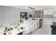 Modern kitchen with white cabinets, island with sink, and view to living room at 36905 Kay Ave, Zephyrhills, FL 33542