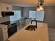Bright kitchen with stainless steel appliances, white cabinets, and a modern island with pendant lighting at 36905 Kay Ave, Zephyrhills, FL 33542