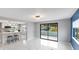 Bright, open-concept living space boasts modern tile flooring and seamless transition to kitchen, perfect for entertaining at 36905 Kay Ave, Zephyrhills, FL 33542