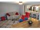 Cozy living room with sofa and stylish red chair, opening to a modern kitchen and dining area with wooden table at 36905 Kay Ave, Zephyrhills, FL 33542