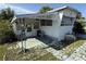Exterior view of a cozy, single-story home with a covered porch, front door, and small landscaped area at 37402 Hammond Dr, Zephyrhills, FL 33541