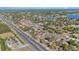 Expansive aerial view of a residential area with mature trees, multiple lakes, and a long highway at 6009 County Line Rd, Spring Hill, FL 34606