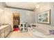 Bright bathroom features a soaking tub, tiled floors, and a stylish lighting fixture at 6009 County Line Rd, Spring Hill, FL 34606