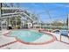 Screen enclosed pool with brick accents and metal pool access ladder at 6009 County Line Rd, Spring Hill, FL 34606