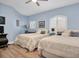 Cozy bedroom with two twin beds, hardwood floors, and a ceiling fan at 6224 Vista Verde W Dr, St Petersburg, FL 33707