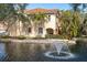 Exterior view of a charming home overlooking a beautiful lake with a fountain at 6224 Vista Verde W Dr, St Petersburg, FL 33707