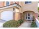 Inviting front entrance with manicured bushes, a covered archway, and white garage door of a two-story townhouse at 6224 Vista Verde W Dr, St Petersburg, FL 33707