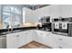 Bright kitchen featuring white cabinets, stainless steel appliances, and modern fixtures and light-toned backsplash at 6224 Vista Verde W Dr, St Petersburg, FL 33707