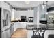 Modern kitchen with stainless steel appliances, a breakfast bar with seating, white cabinets and black countertops at 6224 Vista Verde W Dr, St Petersburg, FL 33707