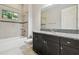 Bathroom with granite countertop, dark wood cabinets, and tiled shower at 10825 Charmwood Dr, Riverview, FL 33569
