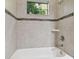 Bathroom features a tiled shower, tub, and a window with greenery outside at 10825 Charmwood Dr, Riverview, FL 33569