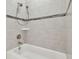 Close-up of a tiled bathtub with a shower head and faucet fixtures at 10825 Charmwood Dr, Riverview, FL 33569