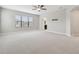 Large carpeted bedroom with ceiling fan, archway, television mount, and a window at 10825 Charmwood Dr, Riverview, FL 33569