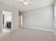 Spacious bedroom featuring plush carpet, neutral paint, and access to a bathroom and hallway at 10825 Charmwood Dr, Riverview, FL 33569