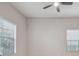 Bright and airy bedroom with two large windows, a ceiling fan and neutral-colored walls at 10825 Charmwood Dr, Riverview, FL 33569