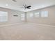 Bright, open bedroom with plush carpeting, ceiling fan, and multiple windows at 10825 Charmwood Dr, Riverview, FL 33569
