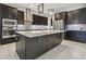 Island kitchen boasts stainless appliances, bar seating, tiled floors, and pendant lighting at 10825 Charmwood Dr, Riverview, FL 33569