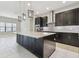 Modern kitchen with stainless steel appliances, dark cabinets and a large center island with counter seating at 10825 Charmwood Dr, Riverview, FL 33569