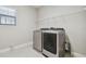 Convenient laundry room with modern washer and dryer, overhead shelving, and bright window at 10825 Charmwood Dr, Riverview, FL 33569