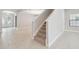 Open-concept living area with staircase, tile floors and abundant light from front door and windows at 10825 Charmwood Dr, Riverview, FL 33569