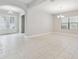 Bright, airy living room boasts tiled floors, archway to entrance and natural light from large window at 10825 Charmwood Dr, Riverview, FL 33569