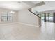 Spacious open-concept living room with tile floors, a staircase and lots of natural light at 10825 Charmwood Dr, Riverview, FL 33569