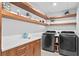 Laundry room with modern washer/dryer, floating shelves, and cabinets at 5027 Sunrise S Dr, St Petersburg, FL 33705