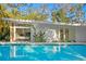 View of pool with the house in background, lush landscaping, and modern architectural design at 5027 Sunrise S Dr, St Petersburg, FL 33705