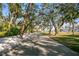 A scenic street view with mature trees leading to the waterfront at 5027 Sunrise S Dr, St Petersburg, FL 33705