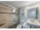Bathroom featuring a tiled shower with glass doors, white sink, and white toilet at 6051 Sun Blvd # 504, St Petersburg, FL 33715