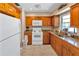 Functional kitchen featuring wood cabinets, tile floors, and a window overlooking the backyard at 8243 Vassar Cir, Tampa, FL 33634