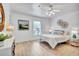 Bright bedroom featuring a ceiling fan, light hardwood floors, and a decorative woven headboard design at 11624 Monette Rd, Riverview, FL 33569