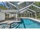 The screened-in pool features a spa, outdoor dining area, and lush landscaping, perfect for relaxation at 11624 Monette Rd, Riverview, FL 33569