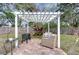 Paver patio features a pergola, comfortable seating, and planting area, ideal for outdoor enjoyment at 1744 Colmar Dr, Holiday, FL 34690