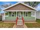 Charming home with green exterior, inviting front porch, and well-manicured lawn offering curb appeal at 2715 14Th N Ave, St Petersburg, FL 33713