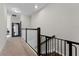 Hallway with carpet flooring, leading to bedrooms, has white banister and a decorative mirror at 29913 Southwell Ln, Wesley Chapel, FL 33543