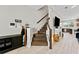 Open-concept living space featuring a staircase, modern fireplace, and seamless flow to the kitchen at 29913 Southwell Ln, Wesley Chapel, FL 33543