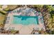 Aerial view of a community pool with lounge chairs, surrounded by lush landscaping and sunny skies at 29913 Southwell Ln, Wesley Chapel, FL 33543