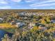 Scenic aerial view of a home with pool, white fence, trees, and a lake in a lush neighborhood at 3870 155Th E Ave, Parrish, FL 34219
