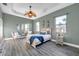 A serene bedroom features neutral walls, two windows, a ceiling fan, and wood-look flooring at 3870 155Th E Ave, Parrish, FL 34219