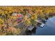A charming red waterfront house with a dock and lush greenery, offering a serene retreat at 3870 155Th E Ave, Parrish, FL 34219