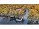 A charming red waterfront house with a dock and lush greenery, offering a serene retreat at 3870 155Th E Ave, Parrish, FL 34219