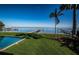 Expansive backyard with lush grass, palm trees, a pool, and a dock overlooking the bay at 3901 Bayshore Ne Blvd, St Petersburg, FL 33703