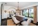 Elegant dining room featuring a rustic wood table, chandelier, and a large window with a view of the manicured lawn at 3901 Bayshore Ne Blvd, St Petersburg, FL 33703