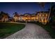 Elegant home at dusk showcasing a beautiful stone exterior, manicured lawn, and paver driveway at 3901 Bayshore Ne Blvd, St Petersburg, FL 33703