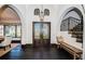 Stunning foyer with decorative double doors, arched windows, dark hardwood floors, and a staircase with decorative tile risers at 3901 Bayshore Ne Blvd, St Petersburg, FL 33703