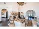 Bright living room featuring a stone fireplace, arched doorways, dark hardwood floors, and ample seating at 3901 Bayshore Ne Blvd, St Petersburg, FL 33703