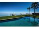 Stunning pool with lush green lawn, a private dock on the water, and tropical palm trees at 3901 Bayshore Ne Blvd, St Petersburg, FL 33703