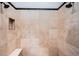 Walk-in shower with neutral stone tile, a built-in niche, a seat, and a dual shower head at 3901 Bayshore Ne Blvd, St Petersburg, FL 33703